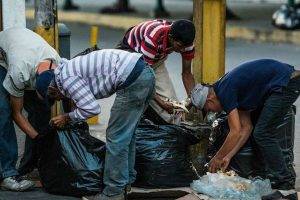 Personas comiendo de la basura